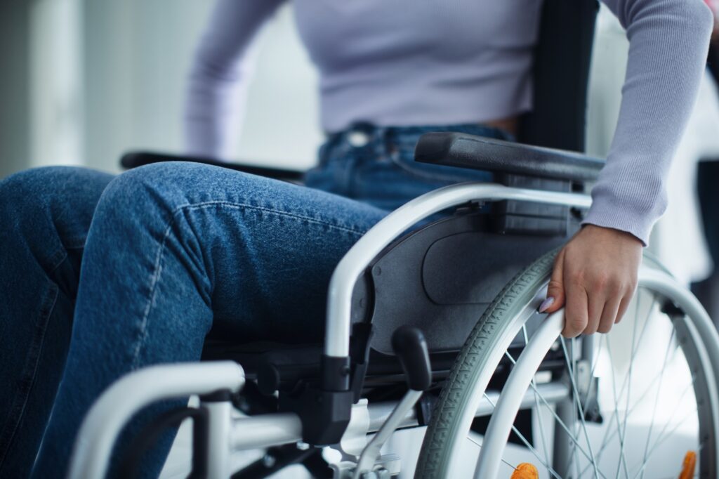 Close-up of young woman at wheelchair in hospital.