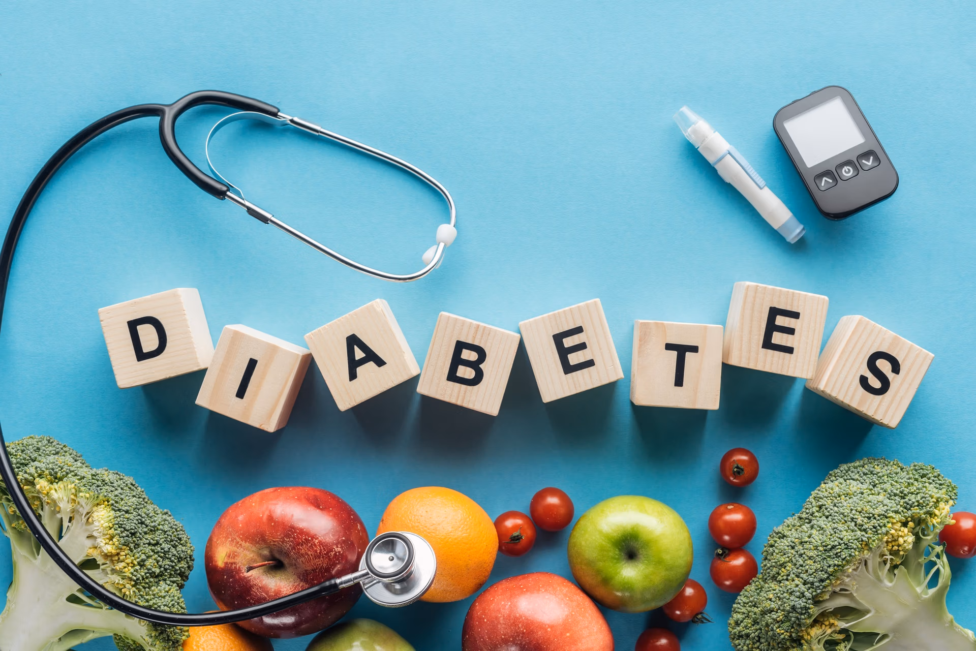 diabetes lettering made of wooden cubes with medical equipment and fruits on blue background
