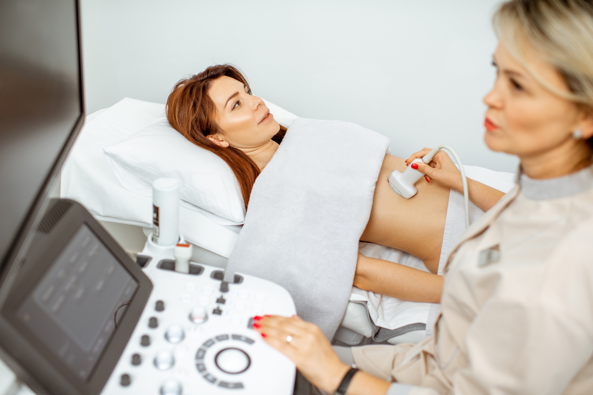 Doctor performs ultrasound examination of a woman