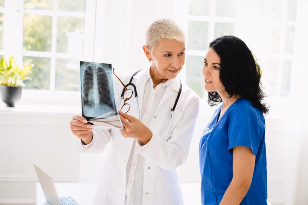 Doctor showing x-ray image of lungs to medical student intern nurse, explaining illness diagnosis