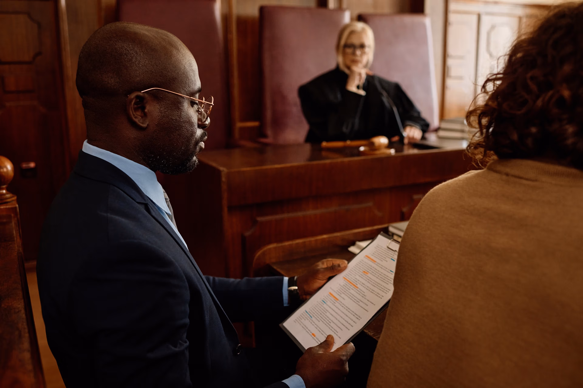 Focus on young confident attorney reading juridical document in court