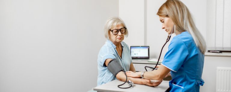 Nurse measuring blood pressure of a senior patient