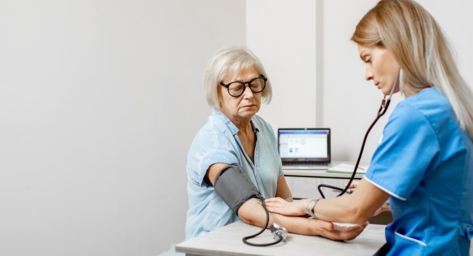 Nurse measuring blood pressure of a senior patient