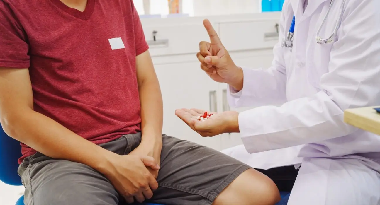 A man consults a doctor in a hospital for male urinary tract infection.doctor advises on symptoms