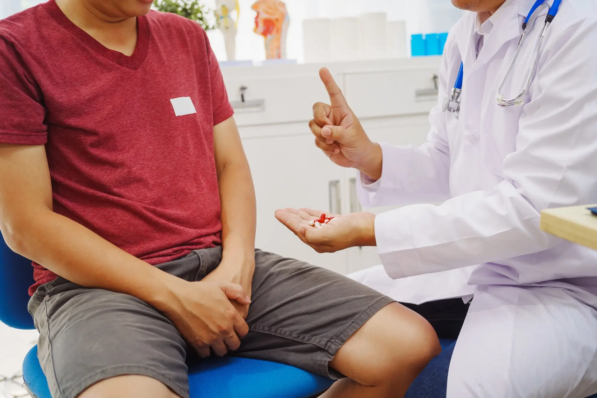 A man consults a doctor in a hospital for male urinary tract infection.doctor advises on symptoms