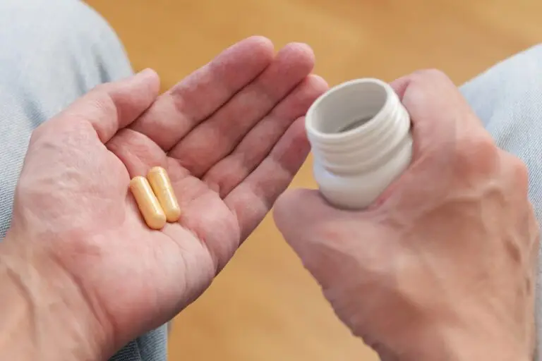 A man poured vitamin B complex pills from a plastic bottle into his palm
