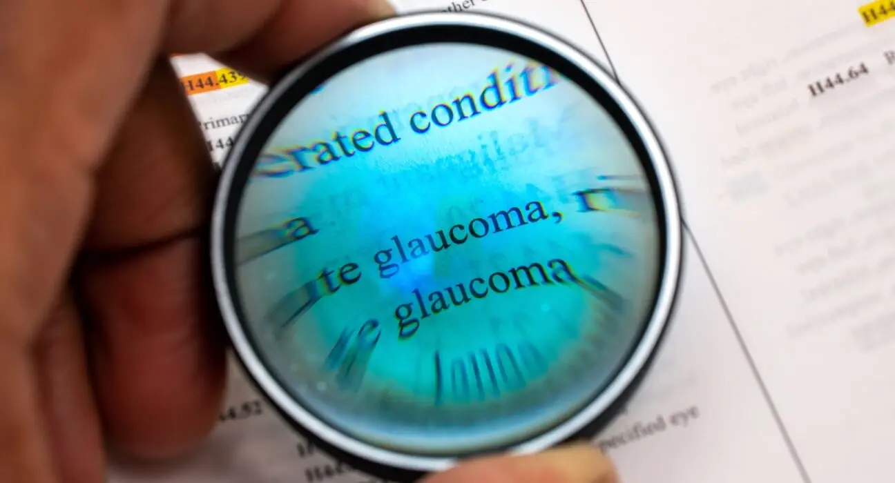 African American man using magnifying glass to look at word glaucoma