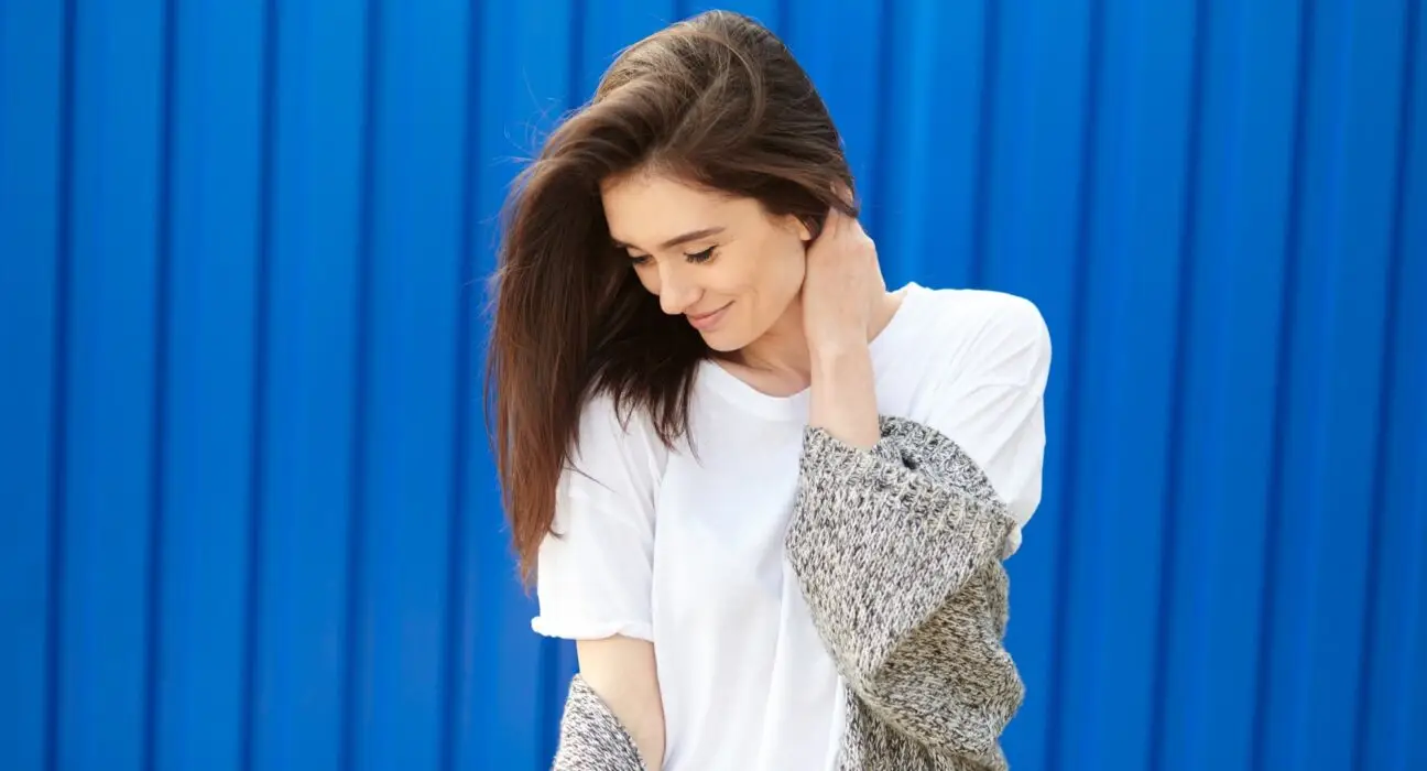 beautiful shy girl smiling on a blue background