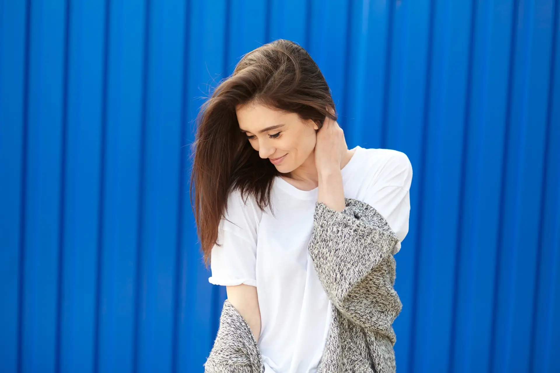 beautiful shy girl smiling on a blue background