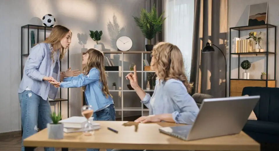 Caucasian female worker sitting at table with opened laptop, trying to reconcile her girls .