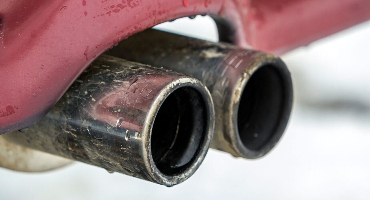 Close up image of a car dual exhaust pipe. Emission of poisonous carbon monoxide gas