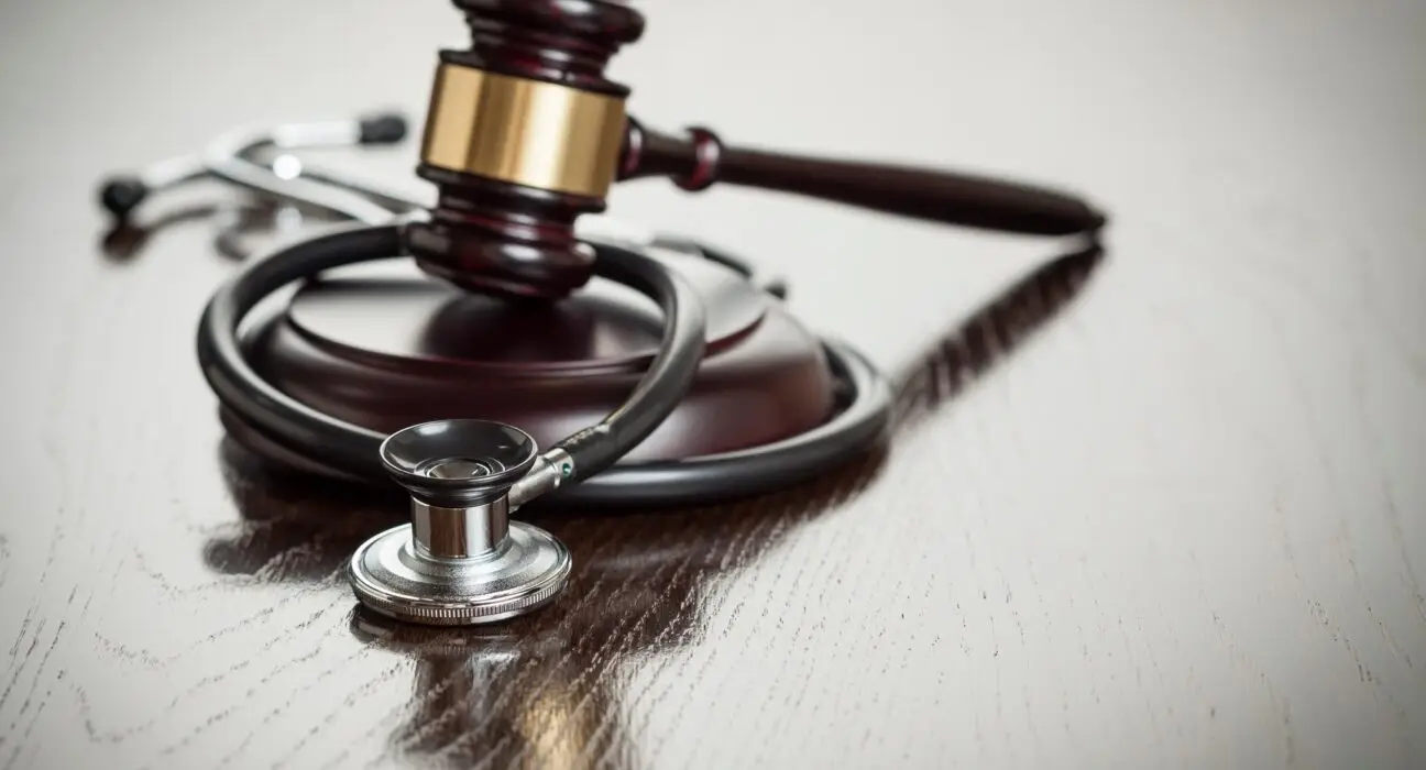 Gavel and Stethoscope on Reflective Table