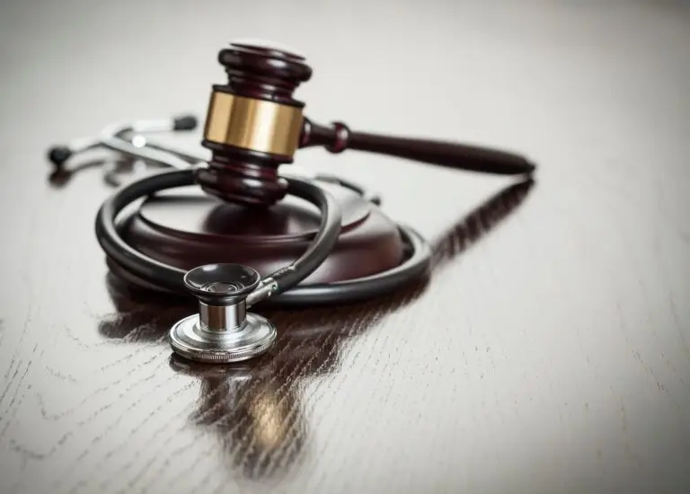 Gavel and Stethoscope on Reflective Table