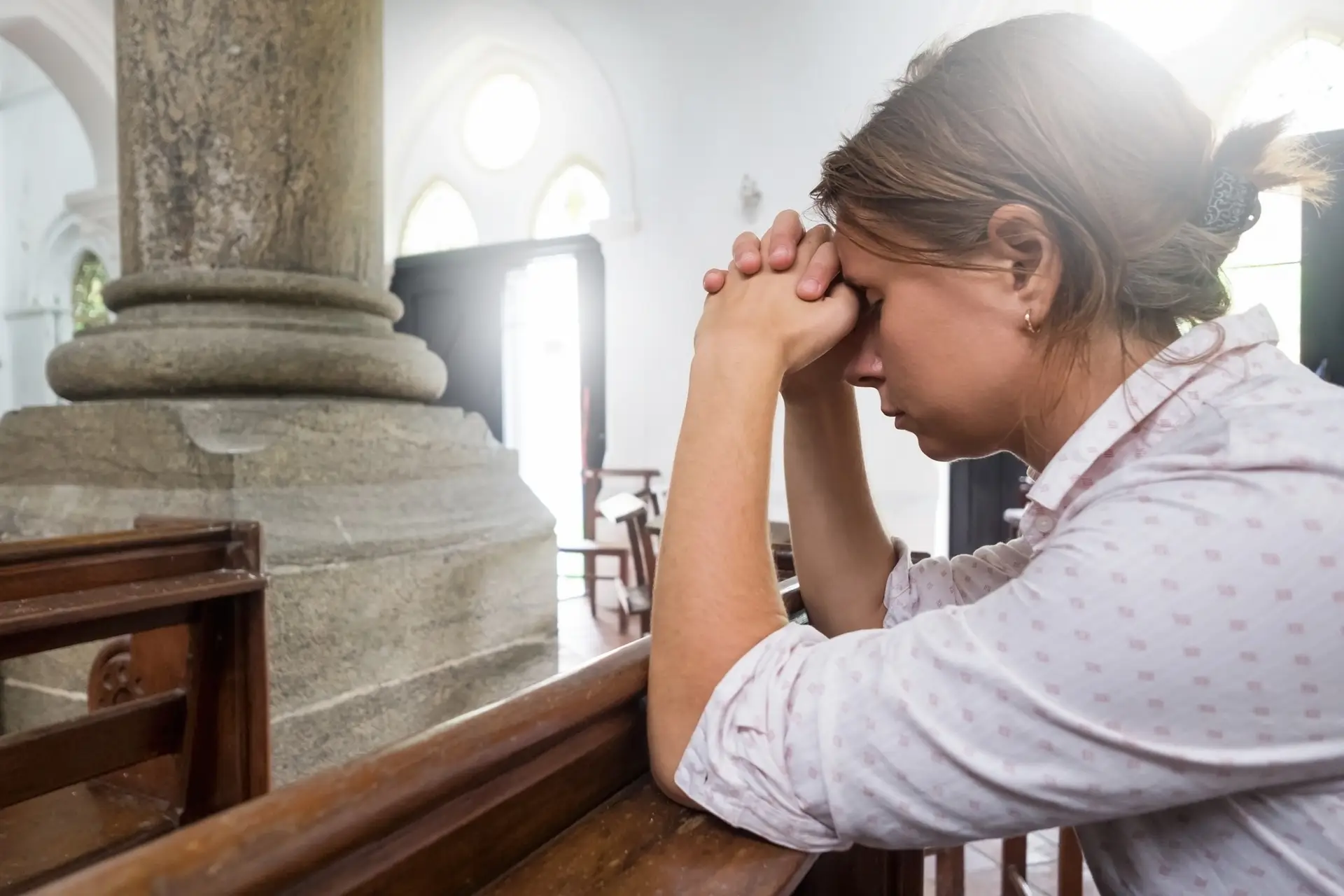 Praying woman in christian church praying God for help.