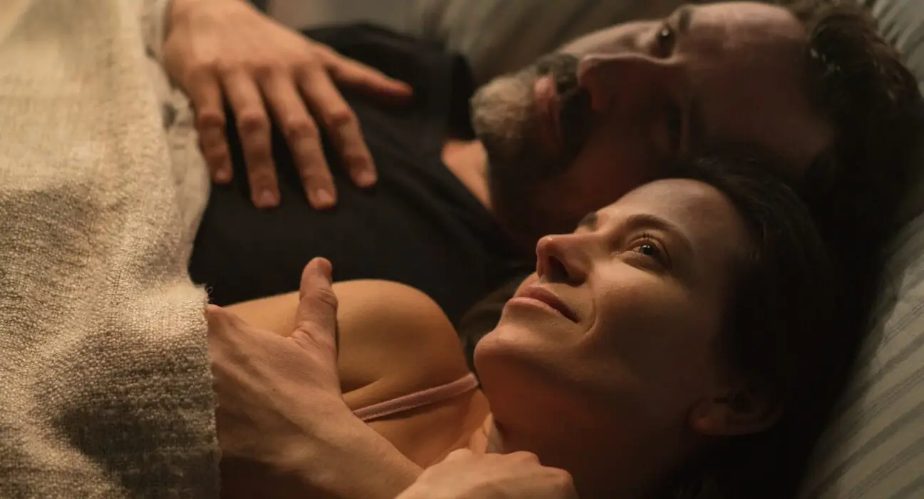 Sad mature man feeling guilty, thinking about cheating his wife, while his wife is snuggling to him