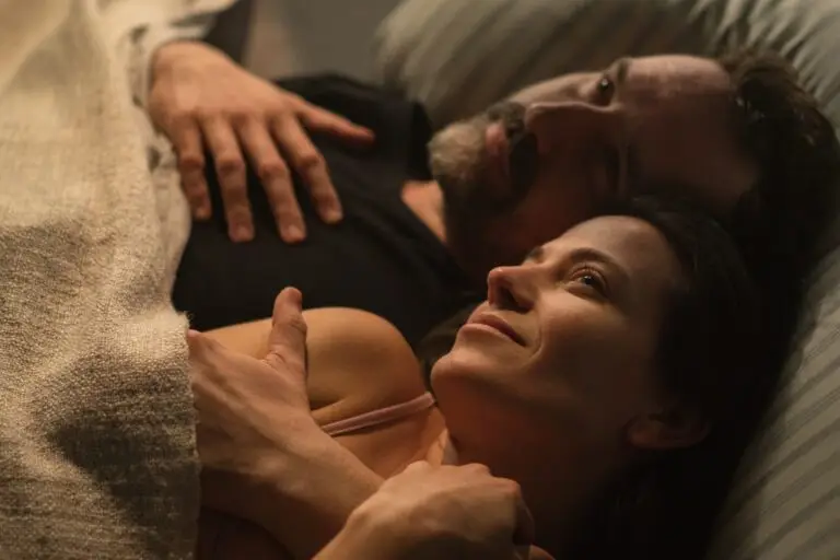 Sad mature man feeling guilty, thinking about cheating his wife, while his wife is snuggling to him