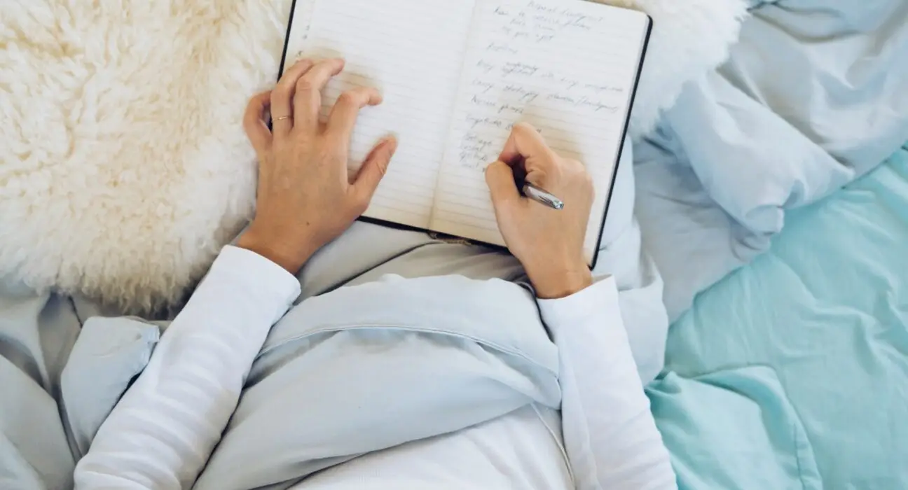 Woman journaling in bed