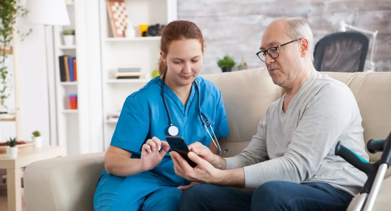 Female doctor in nursing home showing old man