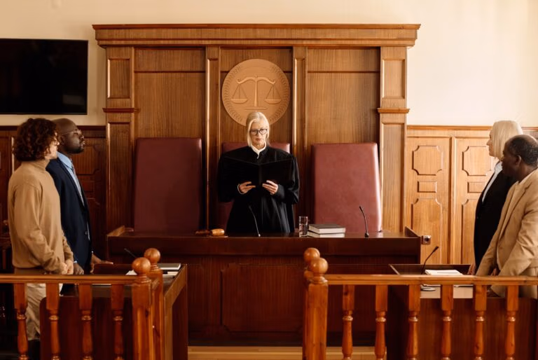 Mature impartial judge passing judgement in front of attorneys and suspect