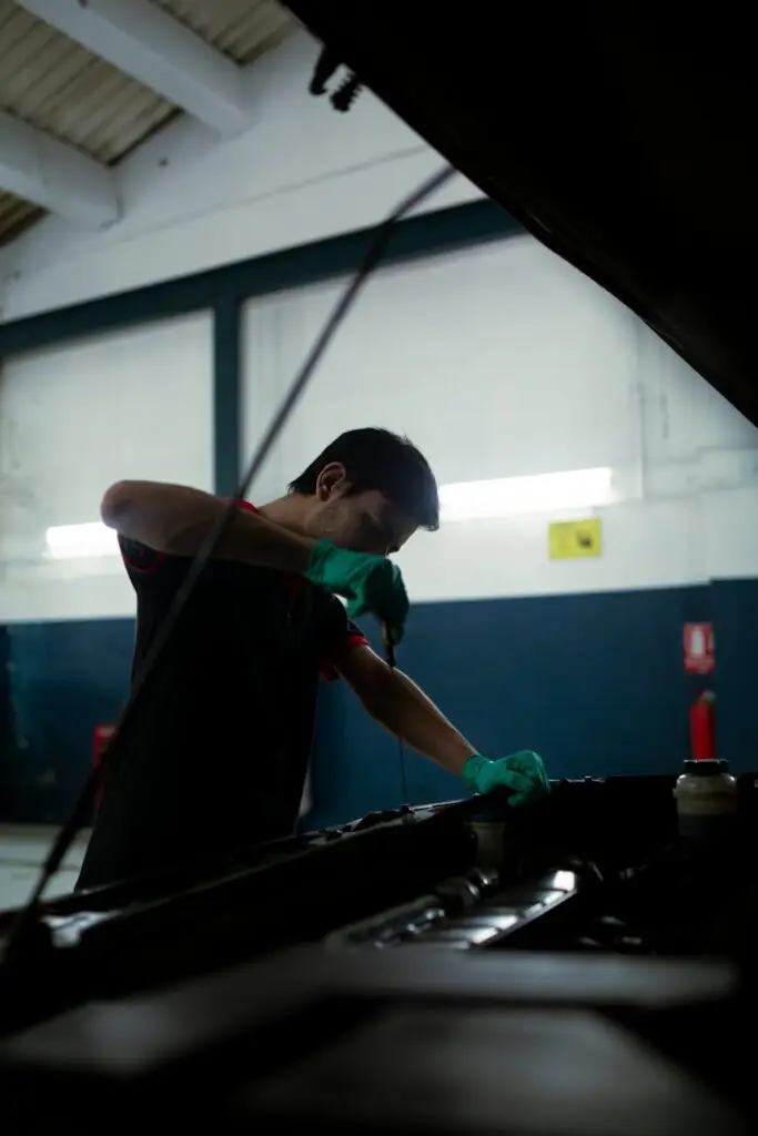 a mechanic checking the oil of a car