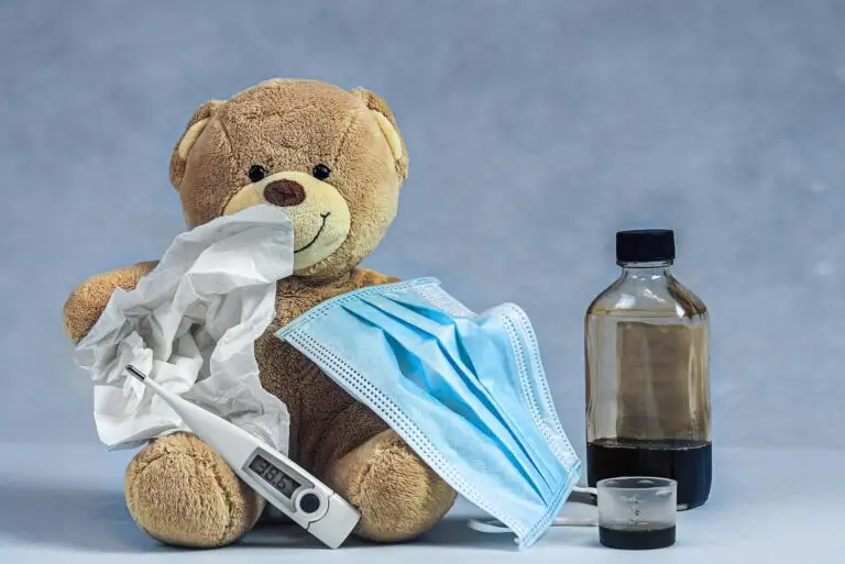close up shot of a teddy bear beside a thermometer