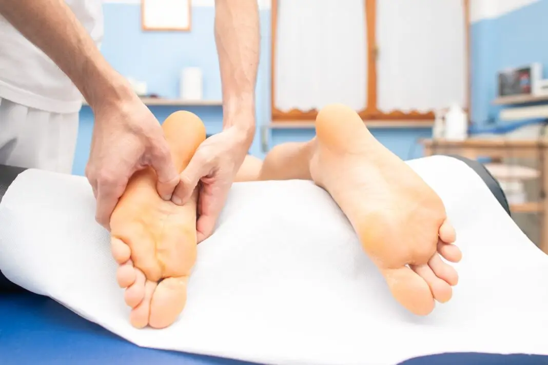 Therapist's hands massaging male foot