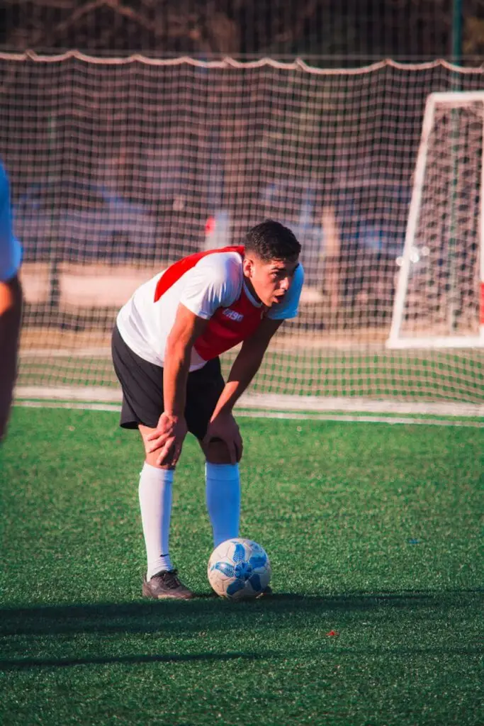 man standing beside soccer ball on soccer field